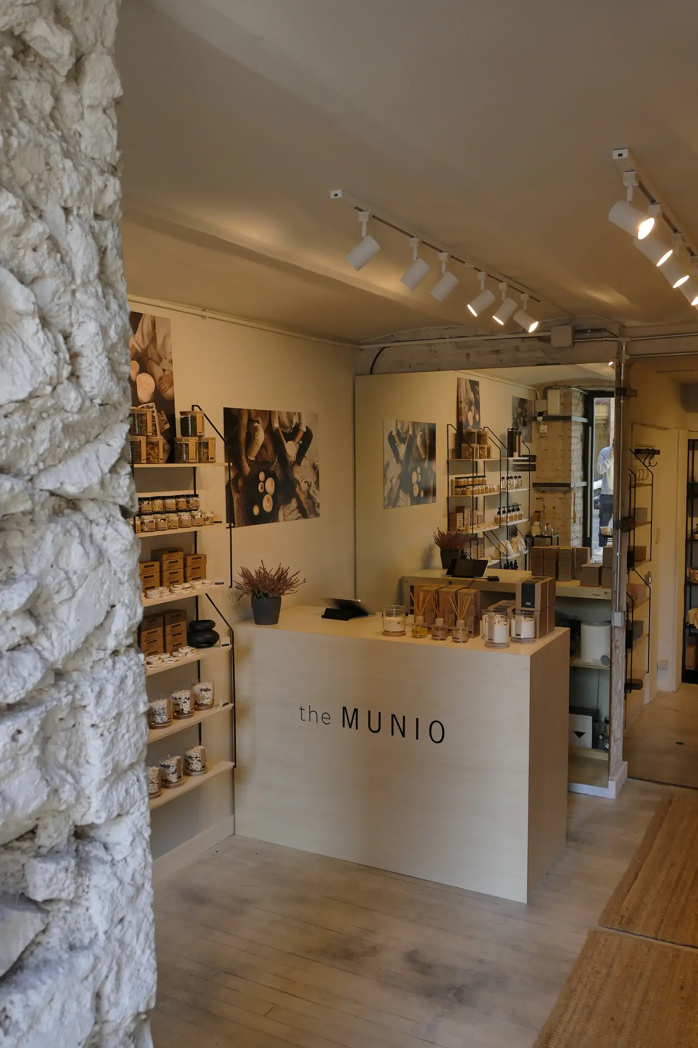 Interior de una boutique de velas en el Eixample, con mostrador claro y jamba de piedra.