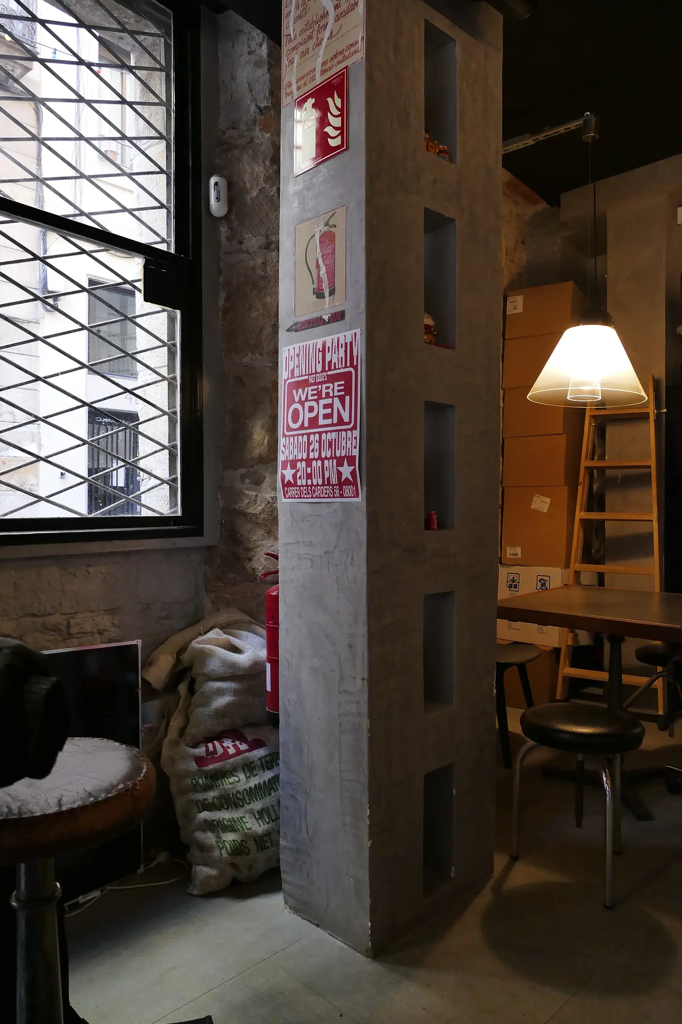 Rincón del comedor con lámpara de pie y muro de ladrillo visto.