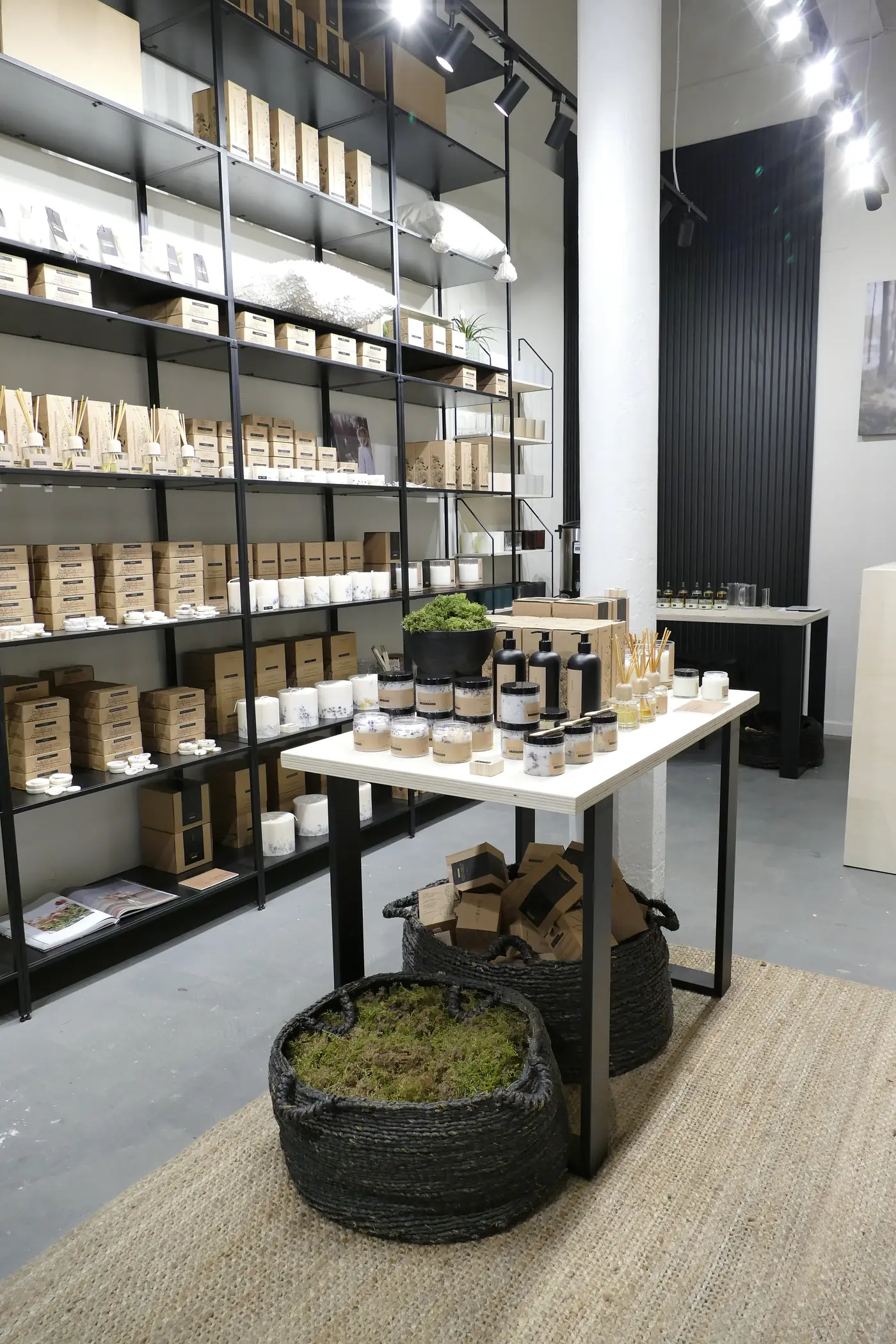 Sala del taller de velas del Born, con mesa central y estanterías negras.